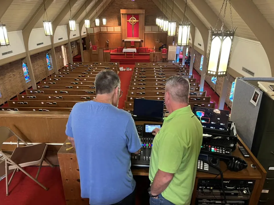 Pinnacle technicians at a digital mixing console overlooking a church sanctuary